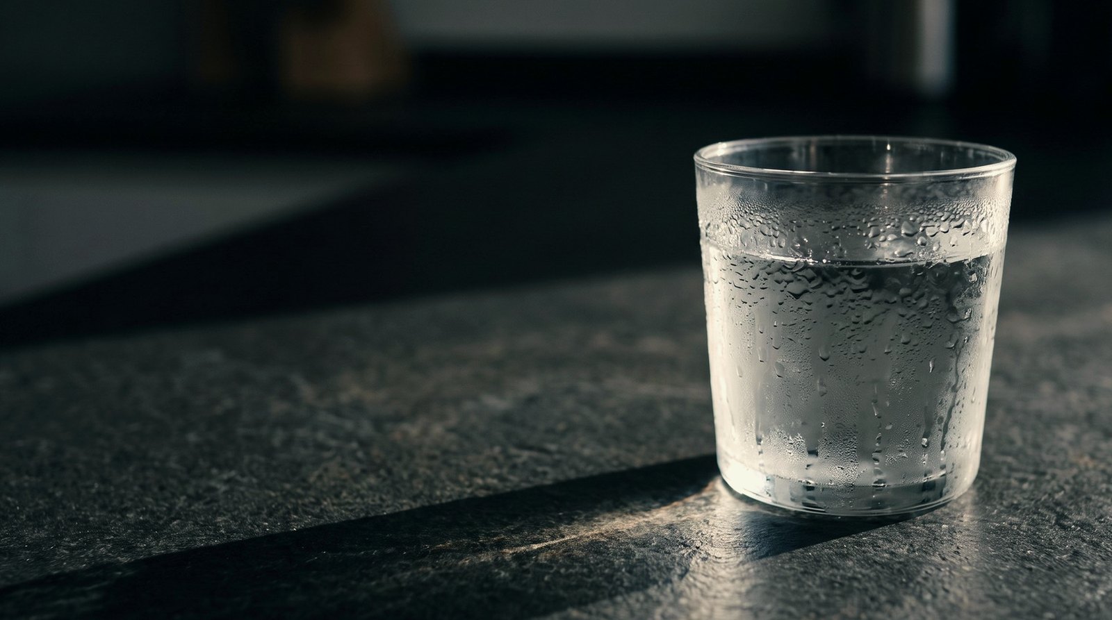 A measured scoop of creatine powder beside a glass of water