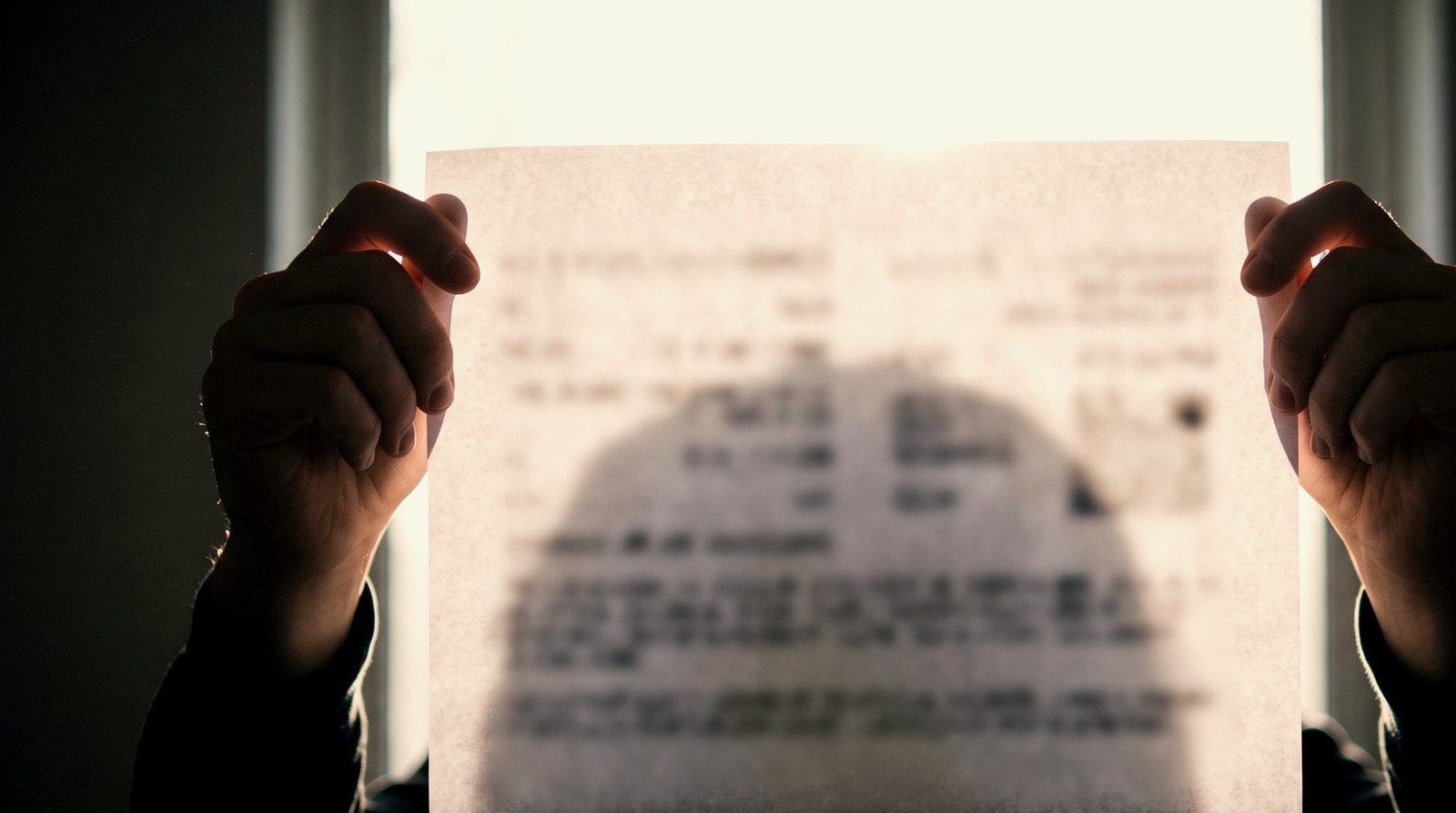 A printed page held up against a bright window